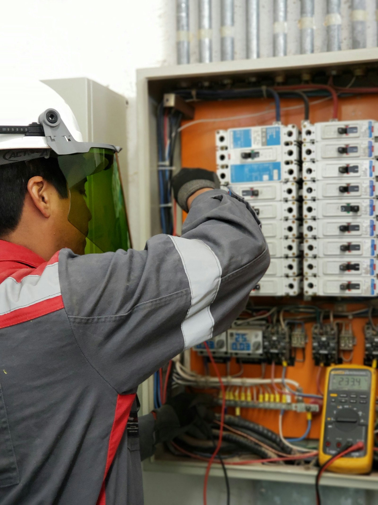 Technician testing an electrical panel with a multimeter